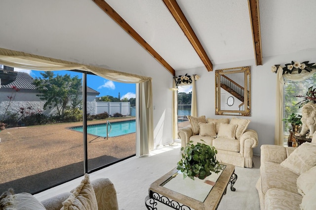 carpeted living room featuring lofted ceiling with beams