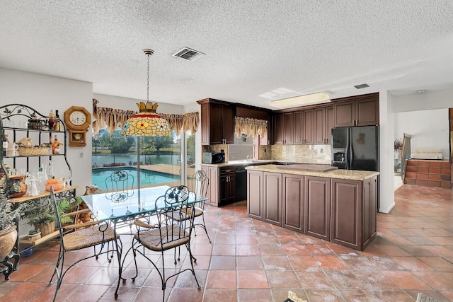 kitchen with a center island, dark brown cabinetry, tasteful backsplash, black appliances, and decorative light fixtures