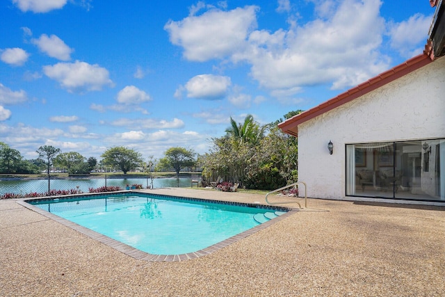 view of swimming pool with a patio and a water view