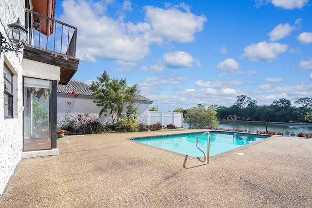 view of swimming pool with a patio and a water view