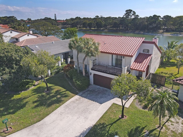 view of front of house featuring a garage, a front lawn, a balcony, and a water view