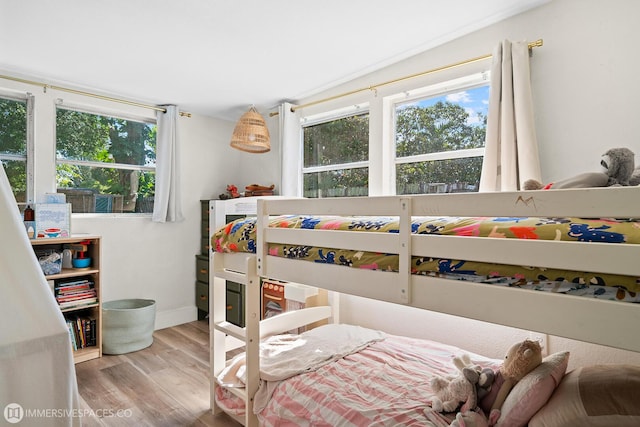 bedroom with multiple windows and light hardwood / wood-style floors