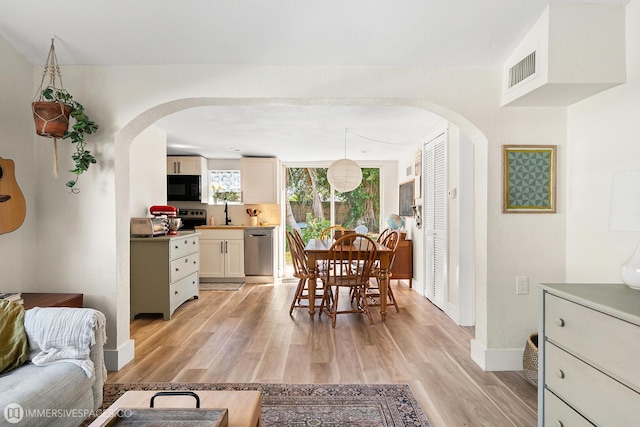 dining room with sink and light wood-type flooring