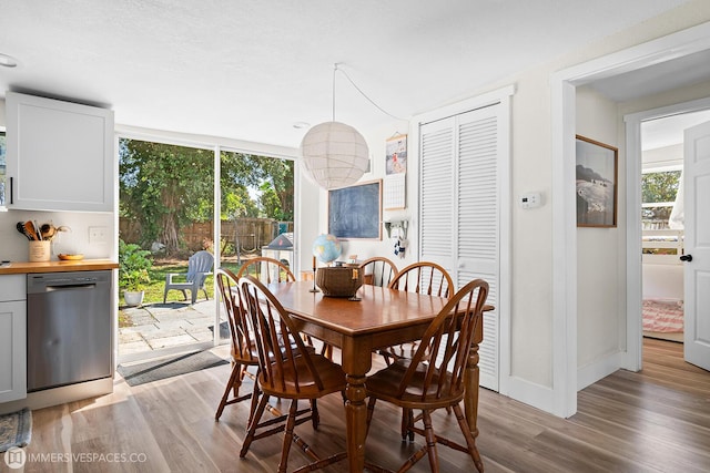 dining space featuring floor to ceiling windows, a wealth of natural light, and light hardwood / wood-style floors