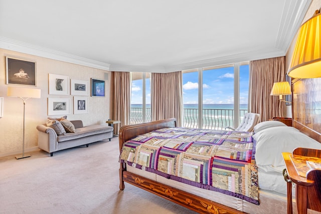 carpeted bedroom featuring a water view, ornamental molding, and access to outside