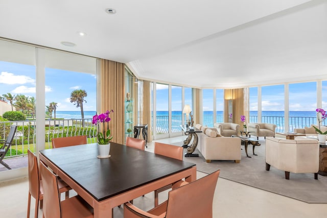 dining area with a water view, expansive windows, and plenty of natural light