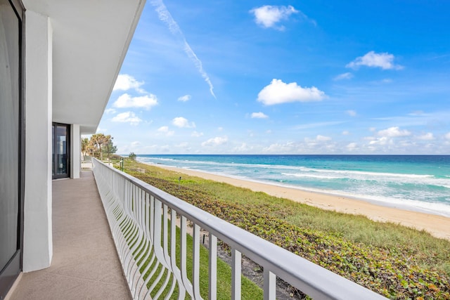 balcony with a water view and a beach view