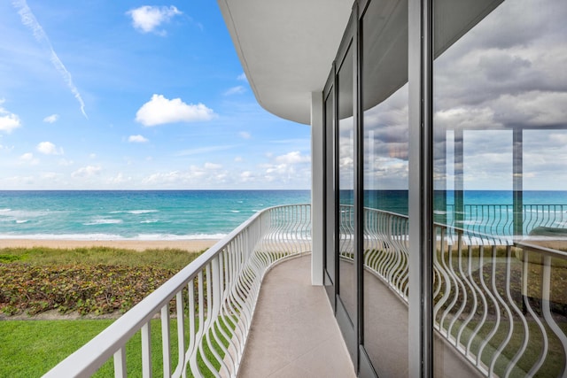 balcony with a water view and a beach view