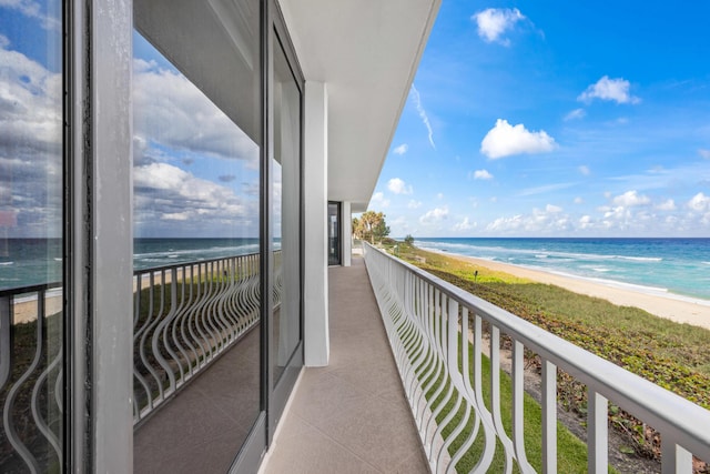 balcony featuring a water view and a beach view