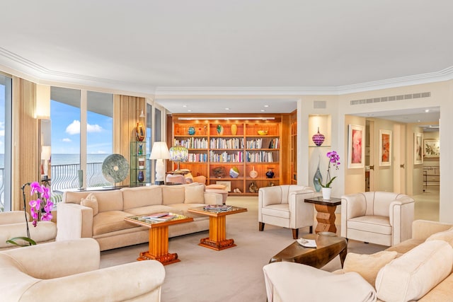 living room with ornamental molding, a water view, carpet floors, and built in features