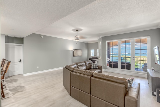 living room with ornamental molding, a textured ceiling, and light hardwood / wood-style flooring