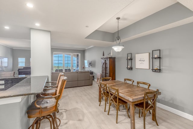 dining room featuring ornamental molding and light wood-type flooring