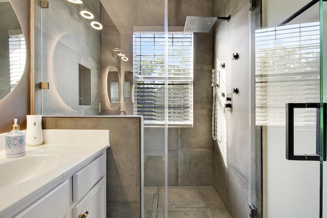 bathroom with vanity, an enclosed shower, and tile walls