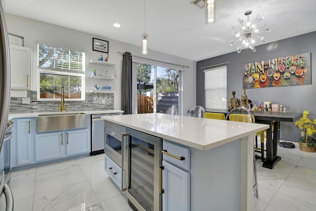 kitchen featuring hanging light fixtures, a center island, sink, and beverage cooler
