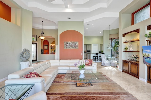 living room featuring a tray ceiling, built in features, and a high ceiling