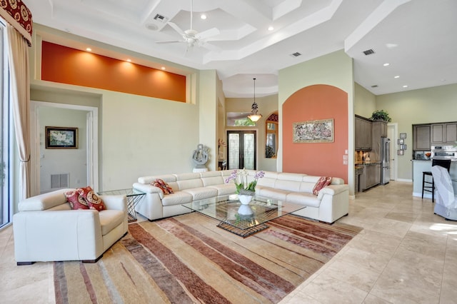 living room with coffered ceiling, a towering ceiling, and ceiling fan