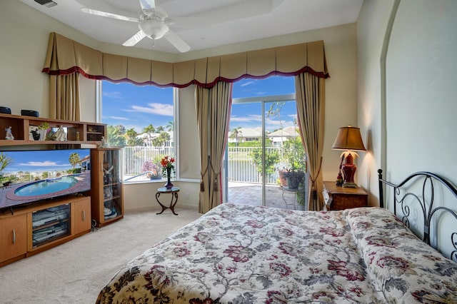 carpeted bedroom with multiple windows, access to exterior, and ceiling fan