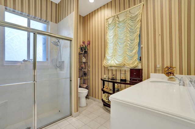 bathroom with vanity, a wealth of natural light, tile patterned floors, and toilet