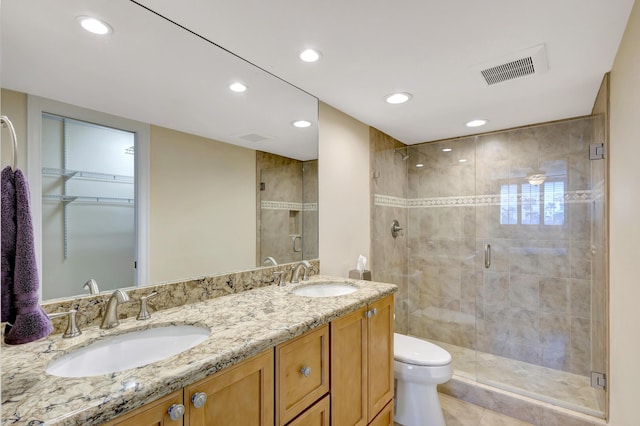 bathroom featuring vanity, toilet, and a shower with door