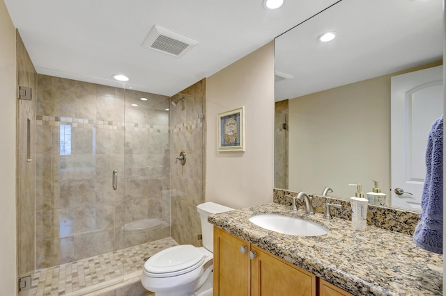 bathroom featuring vanity, an enclosed shower, and toilet