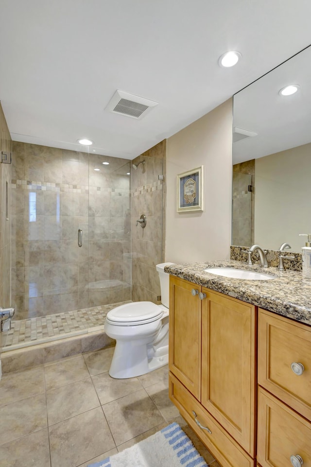 bathroom with vanity, tile patterned flooring, a shower with door, and toilet