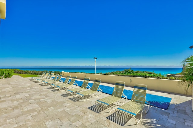 view of pool with a patio area and a water view