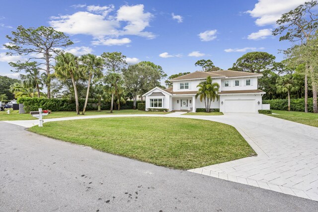 mediterranean / spanish-style home with a garage and a front lawn