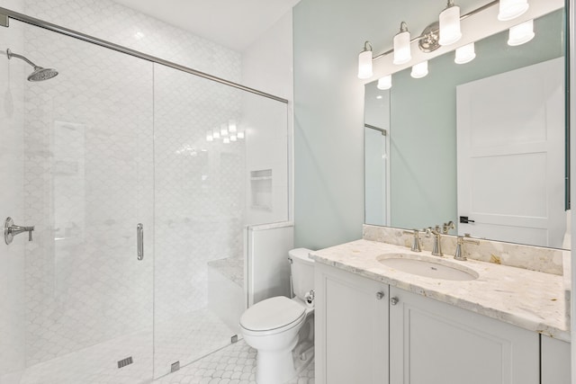 bathroom featuring a shower with door, vanity, and toilet