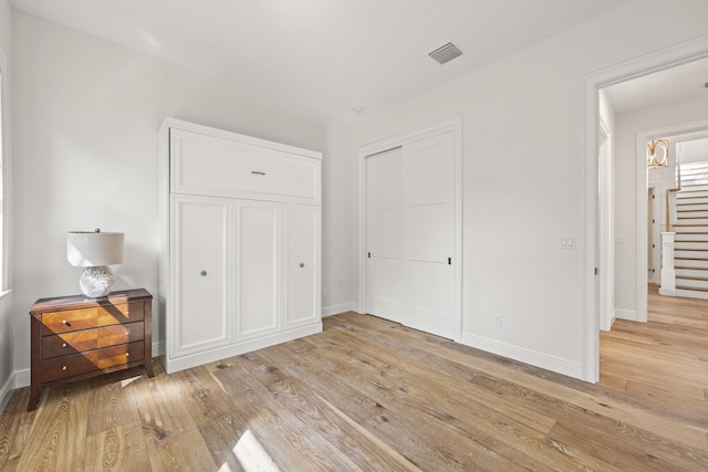 unfurnished bedroom with a closet and light wood-type flooring