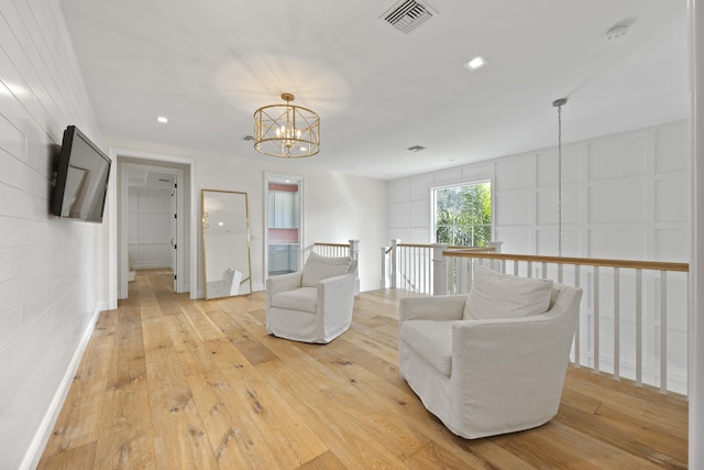 living area featuring an inviting chandelier and light wood-type flooring