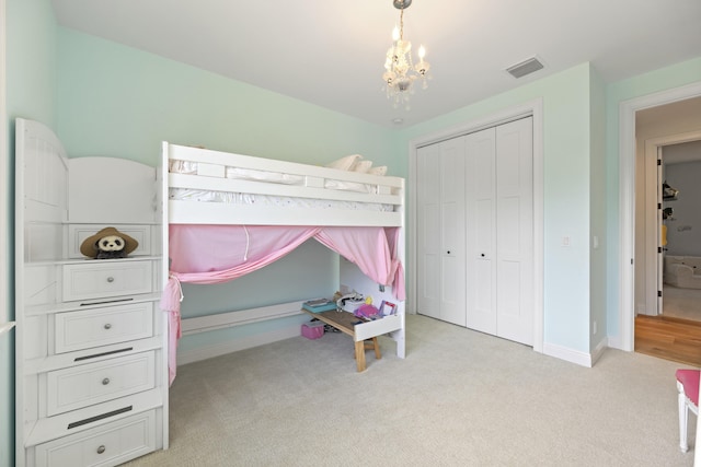 bedroom featuring light carpet, a closet, and a chandelier