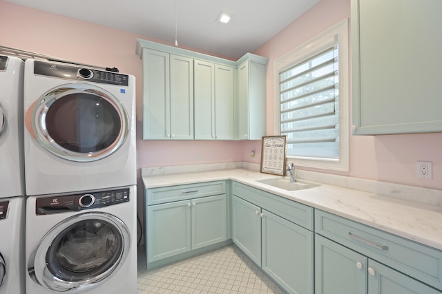 clothes washing area with sink, cabinets, and stacked washer / dryer