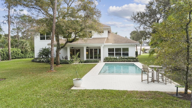 back of property with a lawn, a patio, and ceiling fan