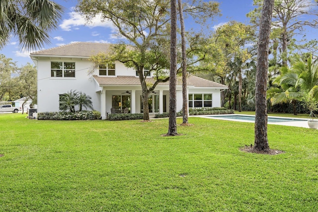 view of front facade with ceiling fan and a front lawn