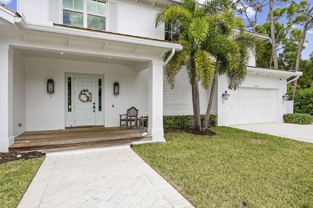 property entrance featuring a garage, a yard, and covered porch