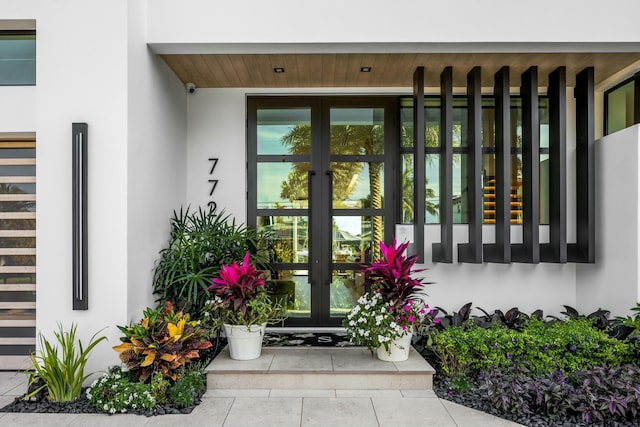 view of exterior entry with french doors and stucco siding