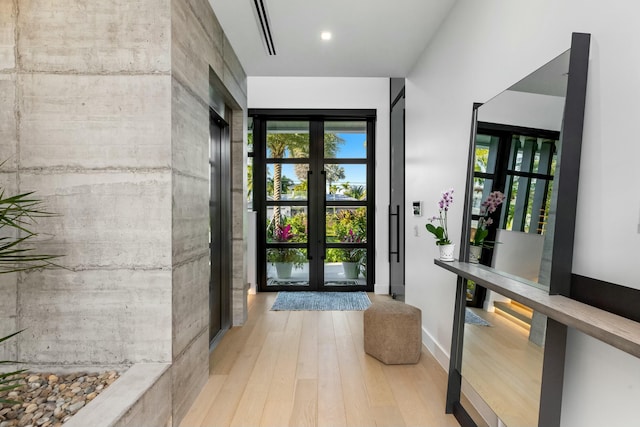 entryway featuring plenty of natural light, wood finished floors, baseboards, and french doors