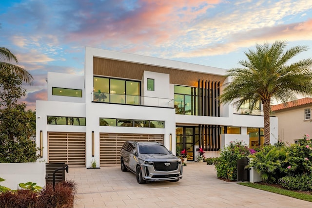 modern home with decorative driveway and stucco siding