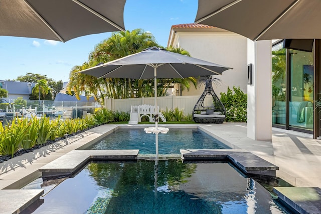 view of pool featuring a pool with connected hot tub, a patio, and fence