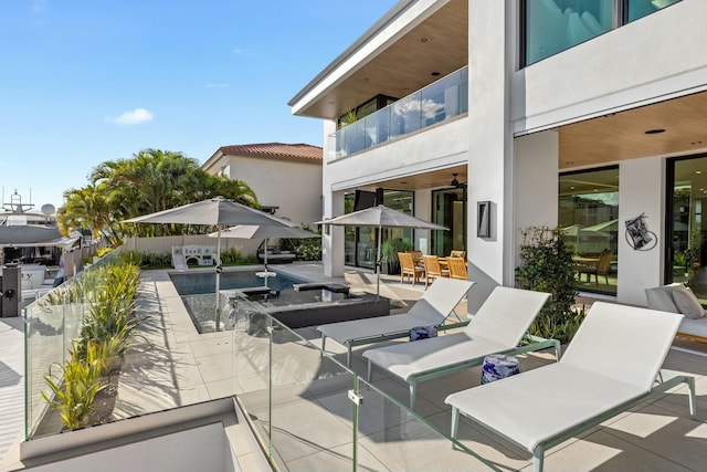 view of patio / terrace with outdoor dining area, a balcony, a fenced in pool, and fence