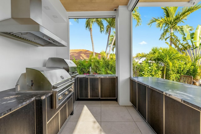 view of patio / terrace with a balcony, area for grilling, and an outdoor kitchen