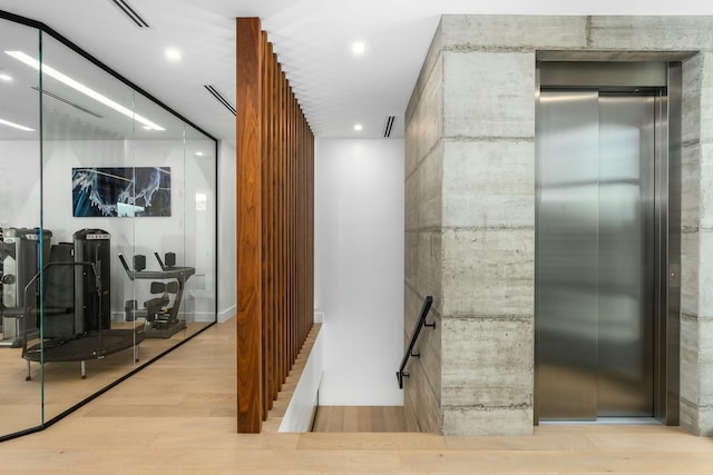 hall with recessed lighting, visible vents, elevator, and wood finished floors