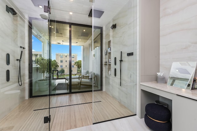 bathroom featuring a shower stall and a wall of windows