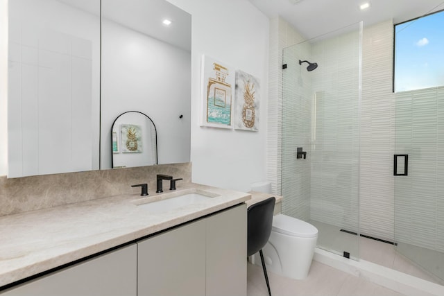 bathroom with vanity, a shower stall, and toilet