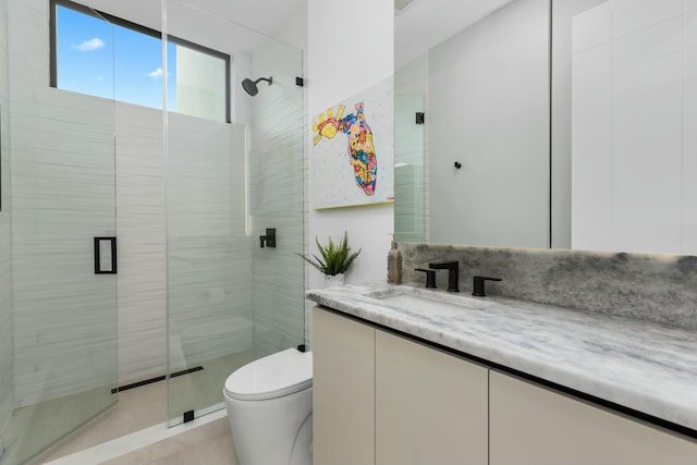 bathroom with vanity, a shower stall, and toilet