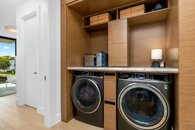 laundry room featuring laundry area, washer and dryer, and light wood-type flooring