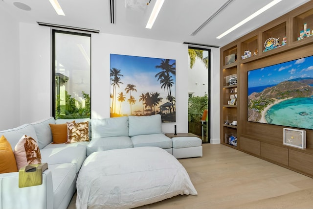 interior space with built in shelves and light wood finished floors