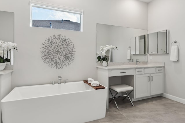 bathroom featuring tile patterned floors, vanity, and a washtub