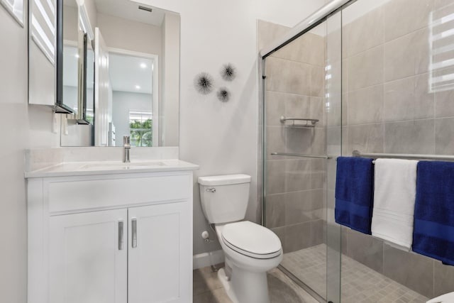 bathroom featuring vanity, toilet, and a shower with shower door