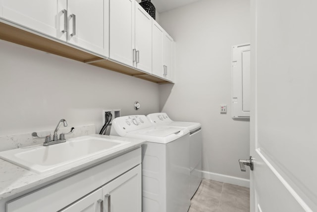 laundry room with light tile patterned flooring, cabinets, sink, and washing machine and clothes dryer